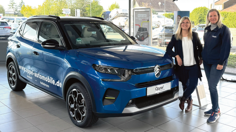 Business Intelligence mit Bissantz - Kunden-Story im Autohaus Magazin, Bild von Susanne Oppel mit Mitarbeiterin vor einem blauen Auto